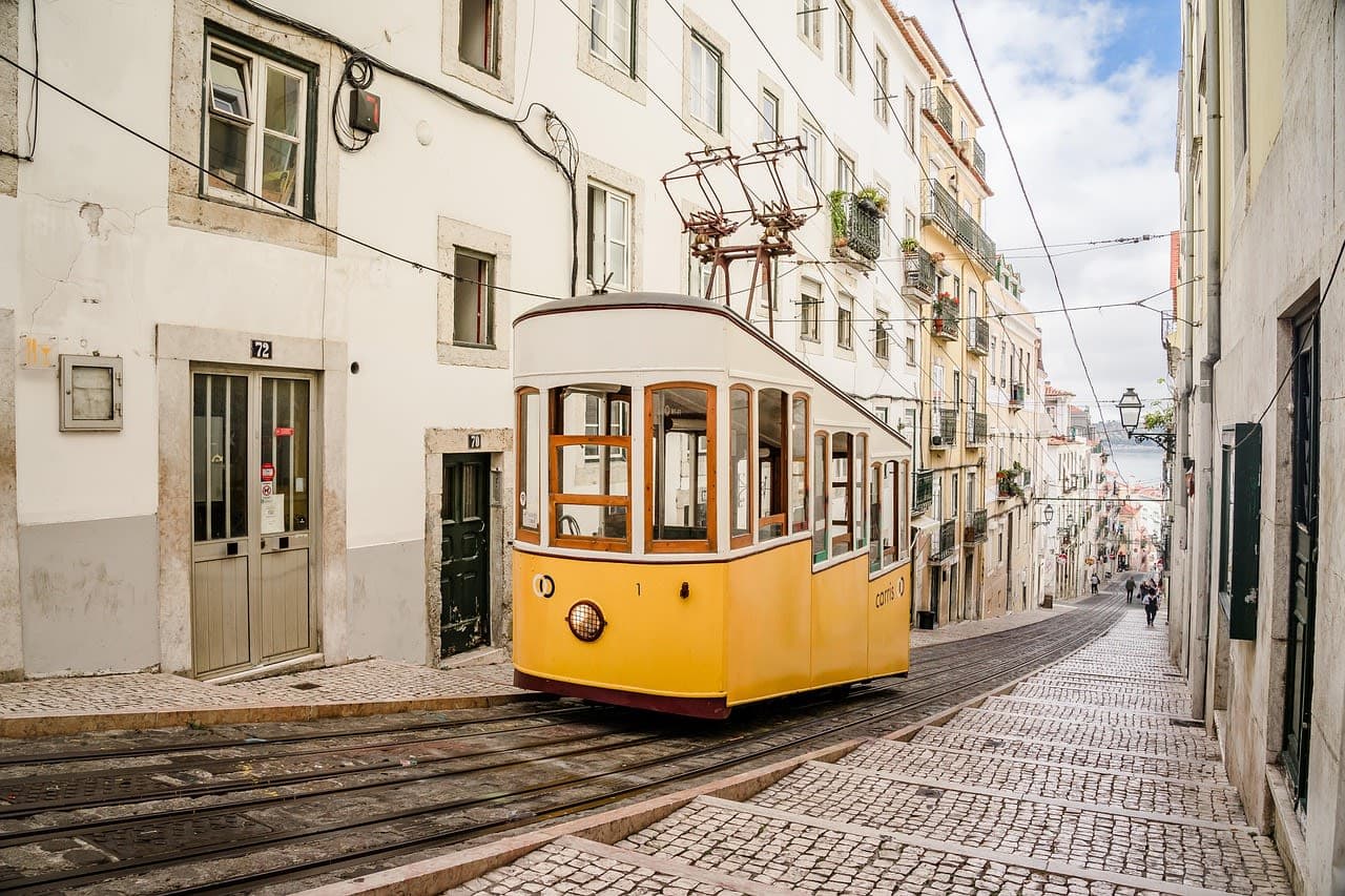 Yellow tram on a cobbled street in Lisbon